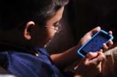 Young boy playing video game on a portable game device